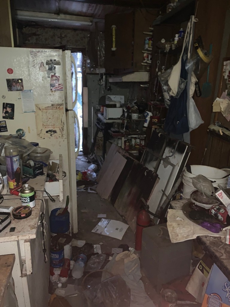 cluttered kitchen with trash and debris all over the room
